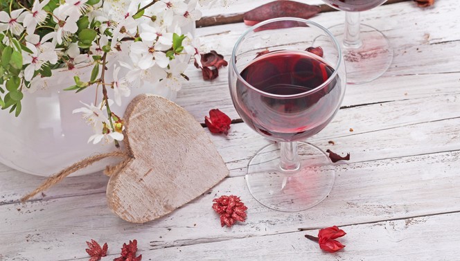 Glas rode wijn en houten hart